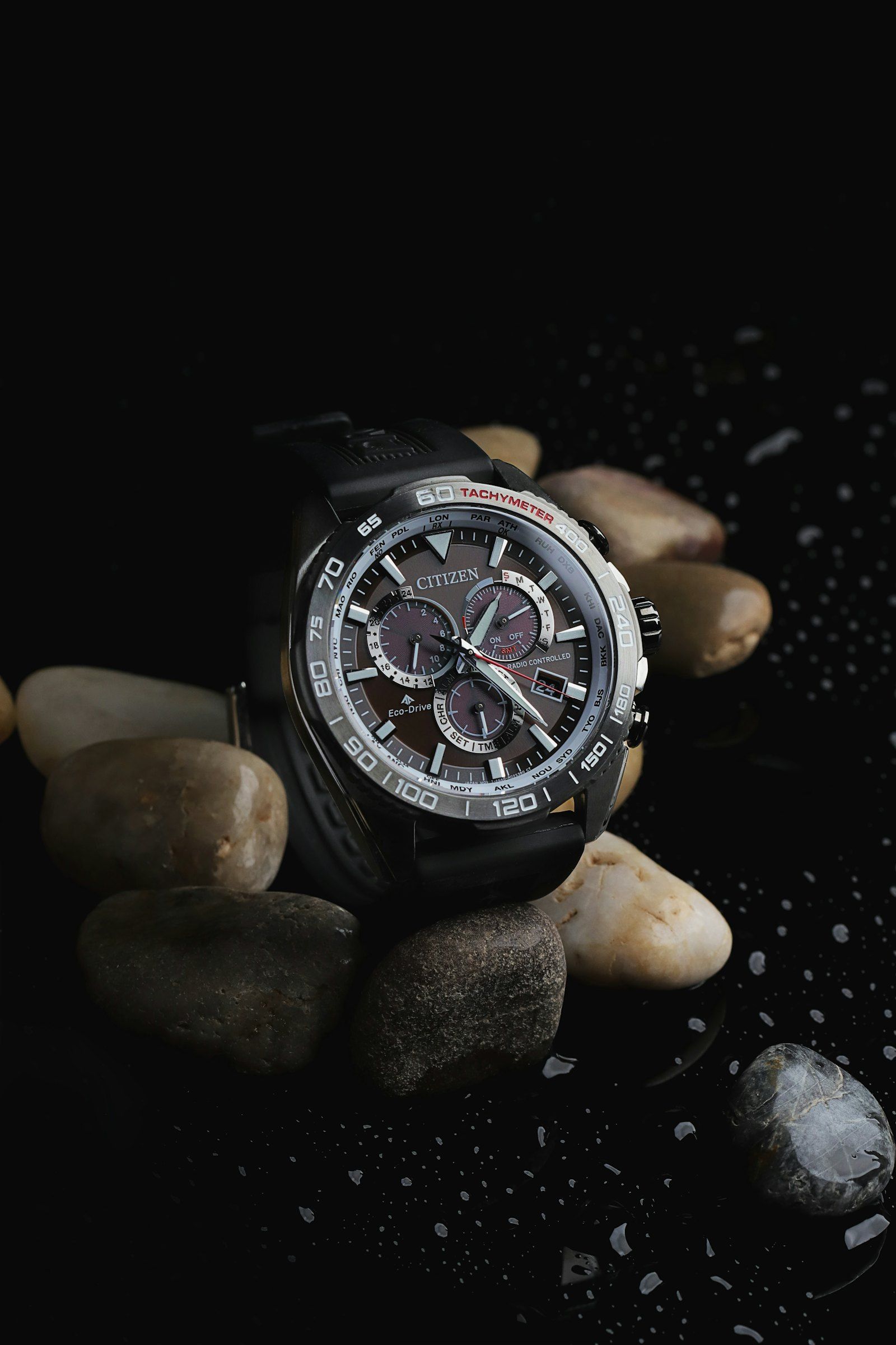 A steel sports watch on a textured surface